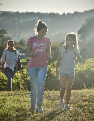 a couple of girls walking across a lush green field